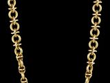 un collier à chaîne en or avec des maillons ronds sur fond noir