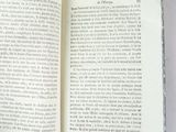 someone is holding a book open on a white surface