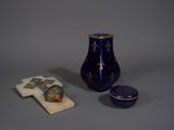 un petit vase bleu et une petite boîte bleue posés sur une table
