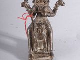 a small statue of a woman sitting on a chair
