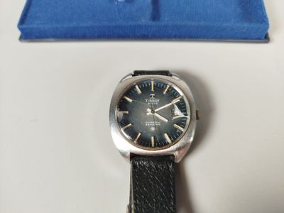 a watch that is sitting on a table next to a blue box