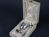a silver spoon and spoon set in a wooden box