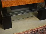 a wooden bench with a glass top and a rug on the floor