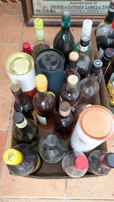 plusieurs bouteilles de vin dans un carton posé par terre