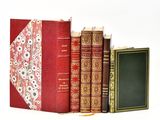 three books sitting next to each other on a white surface