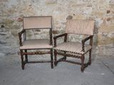 two chairs sitting next to each other in front of a stone wall