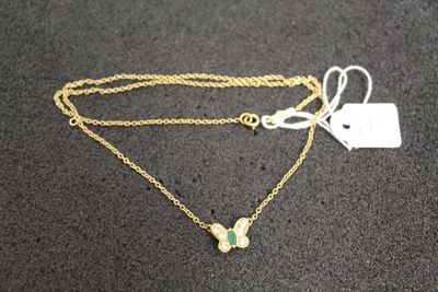 a gold necklace with a butterfly charm on it