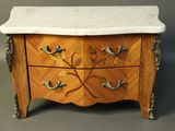 a small marble top chest of drawers with a marble top