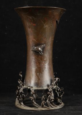 a silver vase with a bird on it on a black background