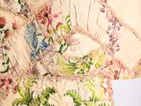 a close up of a table cloth with flowers and leaves on it