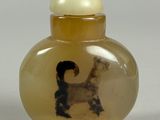 une petite bouteille en verre avec l'image d'un chien à l'intérieur