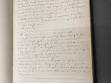 un livre ouvert avec une écriture dessus, posé sur une table
