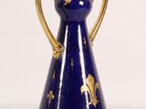 a blue vase with gold decoration on it on a white surface