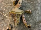 a figurine of a woman laying on a silver surface