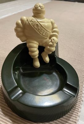 une petite statue représentant un homme assis sur un cendrier