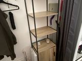a shelf with clothes on it in the corner of a room