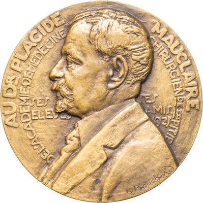 un gros plan sur une médaille d'or, avec un homme en costume-cravate