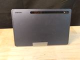 the back of a laptop computer sitting on top of a wooden table