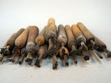 a pile of old wooden baseball bats on a white surface
