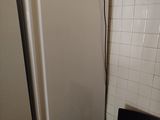 a refrigerator and a chair in a small room