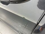 a person standing next to a car that has been painted silver