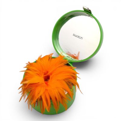a green container with an orange flower inside of it