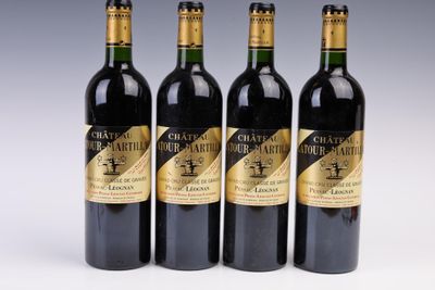 four bottles of wine are lined up on a white surface