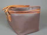 brown and tan leather purse with two zippers on top of it