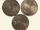 three different coins are shown on a white surface