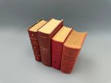 trois livres rouges superposés sur une table