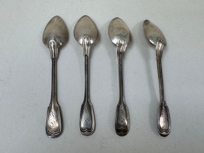four spoons are lined up in a row on a table