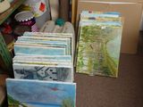 many paintings on the shelves in the room
