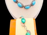collier et bracelet composés de perles turquoise et jaunes, présentés sur un présentoir en bois
