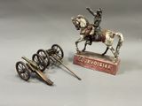 une statue représentant un homme à cheval, à côté d'un canon