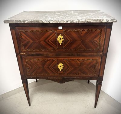an antique chest of drawers with marble top and brass handles