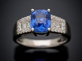 a blue sapphire and diamond ring on a black surface