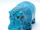 a blue elephant figurine sitting on a white surface