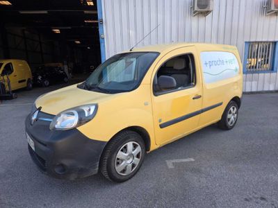 the small yellow van is parked in front of a building