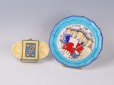 two pieces of art nouveau pottery, including a plate with a picture of a red heart and a blue plate with a picture of a red heart