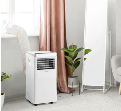un climatiseur blanc posé dans une pièce, à côté d'un miroir