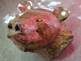 une tête de cochon en argile posée sur une table