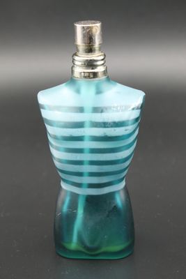 an image of a blue glass perfume bottle on a black surface