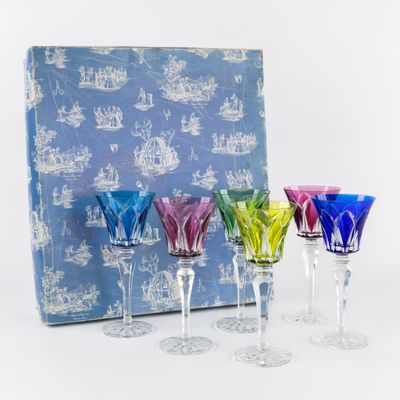 plusieurs verres à vin de différentes couleurs posés devant une boîte bleue