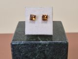 a close up of a pair of earrings sitting on top of a marble block