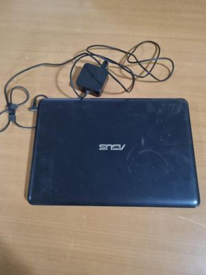un ordinateur portable posé sur une table avec un chargeur