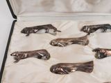 six silver figurines in a case on a white surface