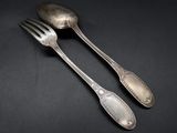 two spoons and a fork on a black background