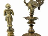 pair of brass figurines of a man and a woman on a pedestal