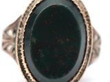 an image of a ring with a green stone