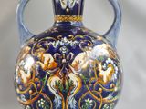 a blue and gold vase sitting on a white surface